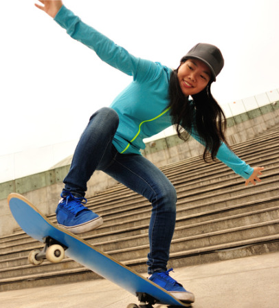 Woman doing a skateboarding trick down stairs.