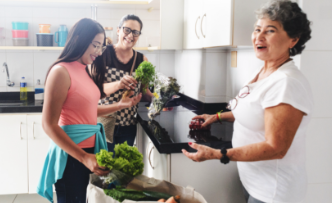 older adults in kitchen with healthy-looking                 groceries